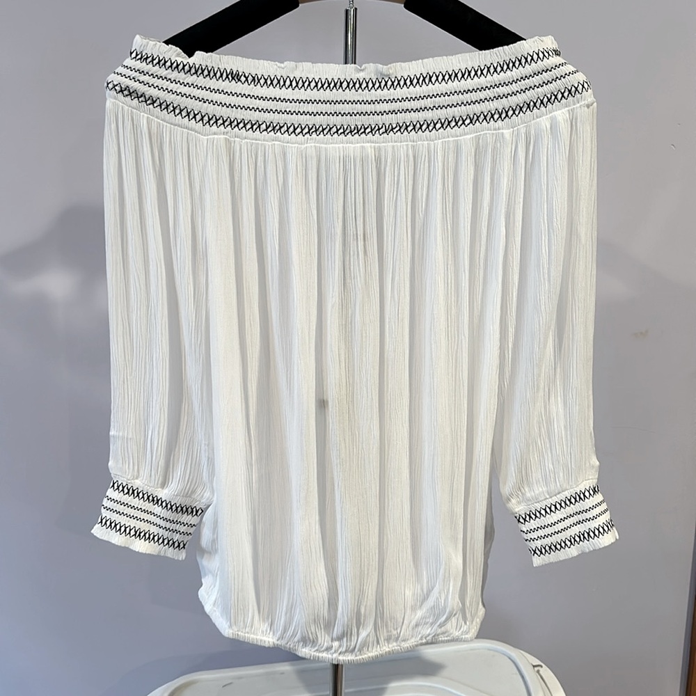 NWT. White. Off the shoulder top. Black embroidering. Flowy. Size extra small